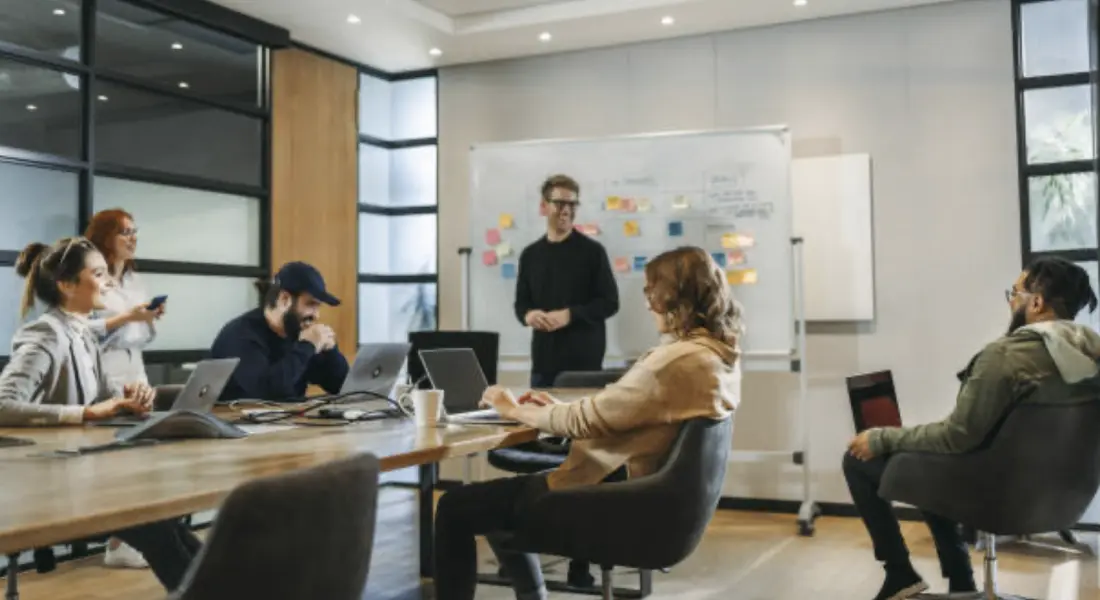 A group of people in a conference room collaborating on ideas.
